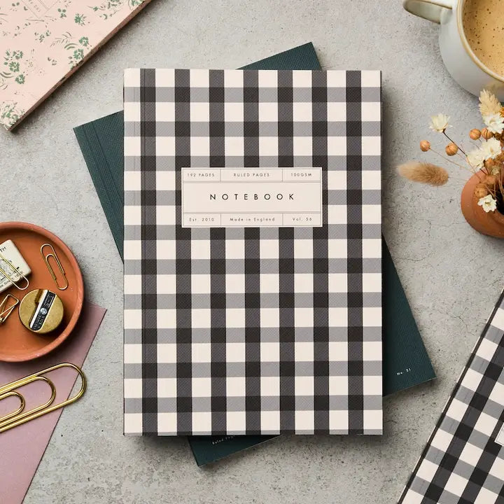 Black and cream gingham notebook on a grey work station