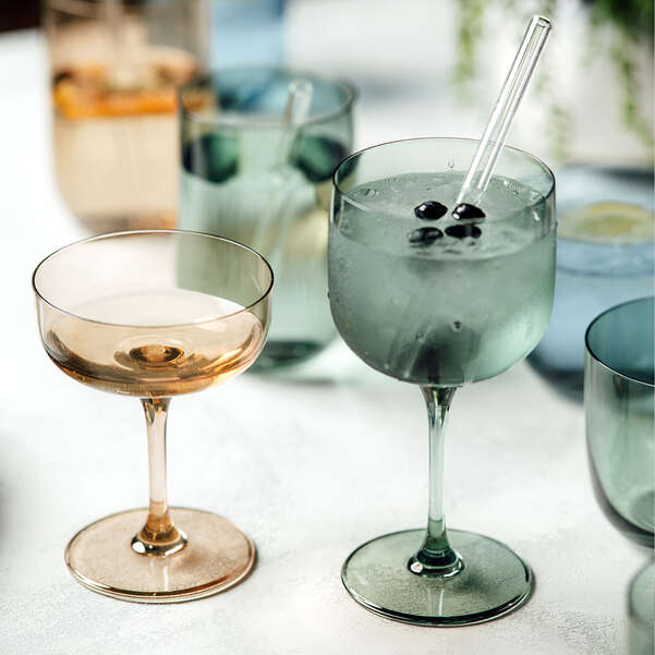 Two glasses of cocktails on a table with a blurred background