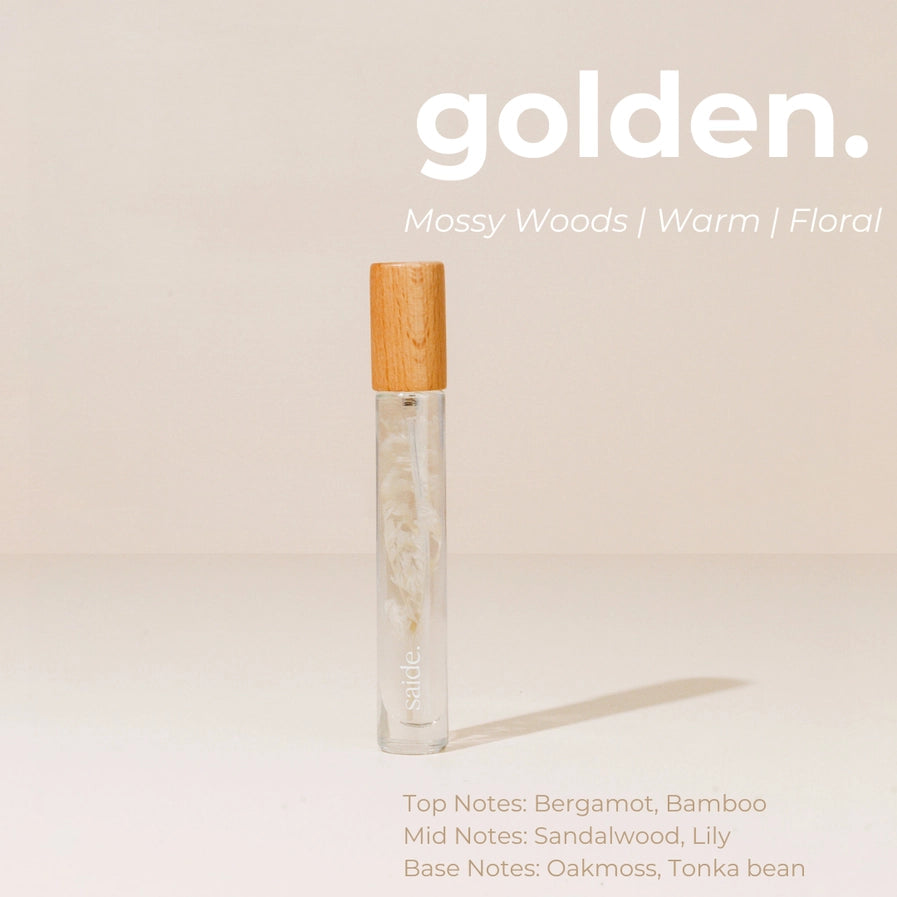 Vial of perfume with wooden cap on a beige background, featuring the brand 'golden.'