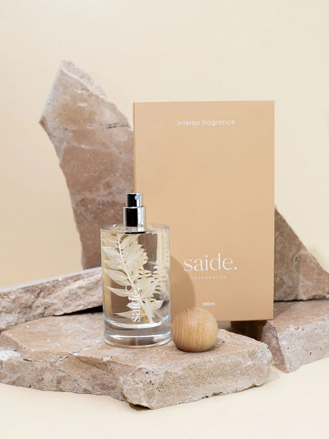 Interior fragrance bottle with floral design on a rock, next to a beige box labeled 'saide'.