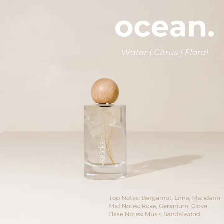 Interior fragrance bottle with wooden cap on a light beige background, featuring the brand 'ocean'.