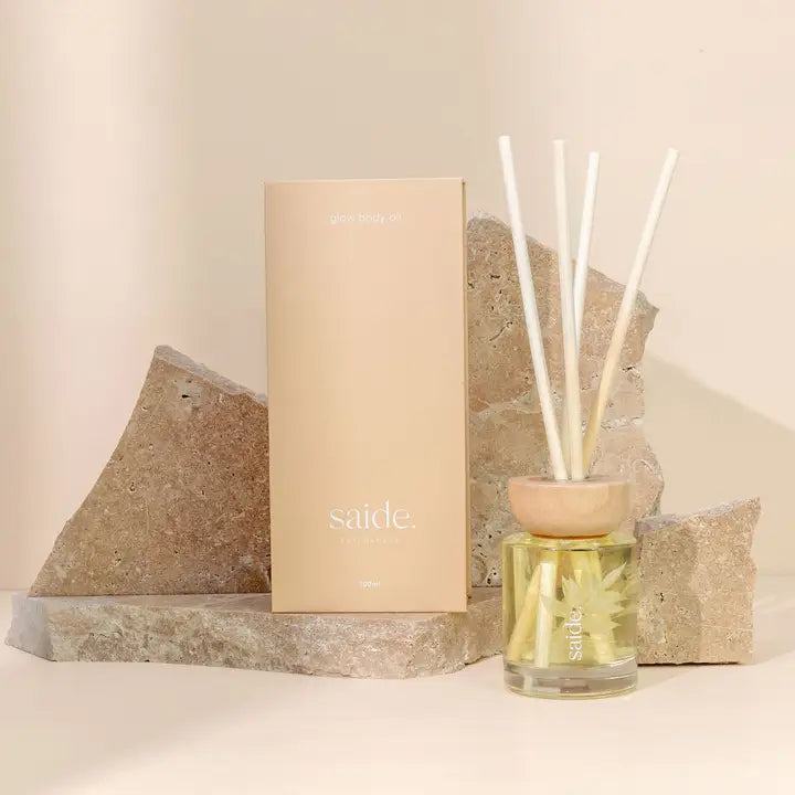 Reed diffuser with packaging on a neutral background