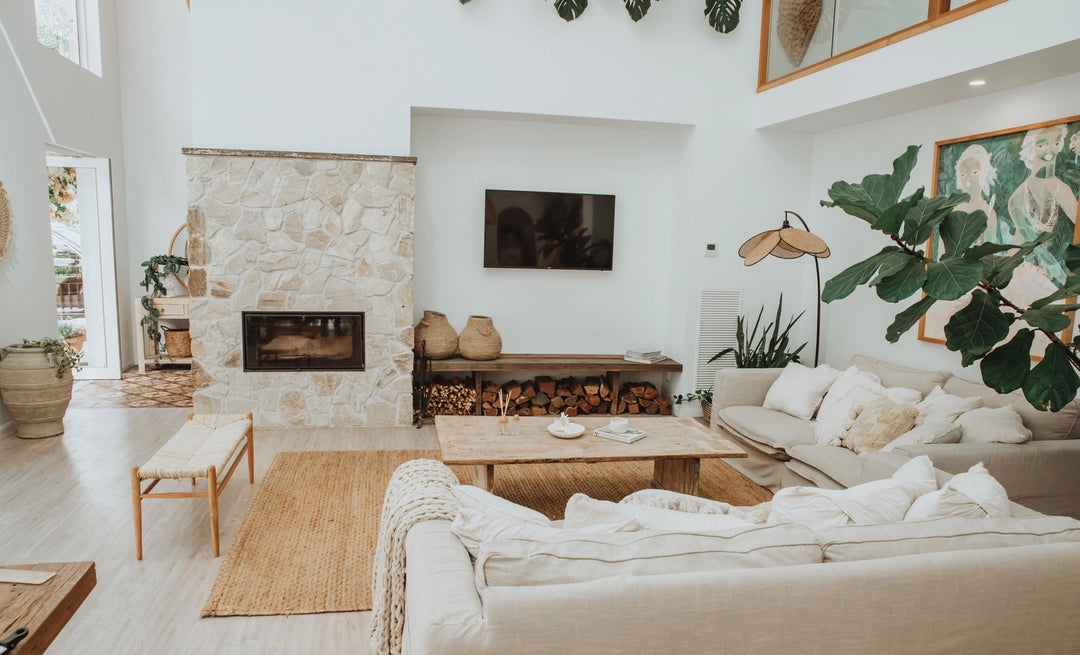 Modern living room with stone fireplace, white walls, and decorative elements.