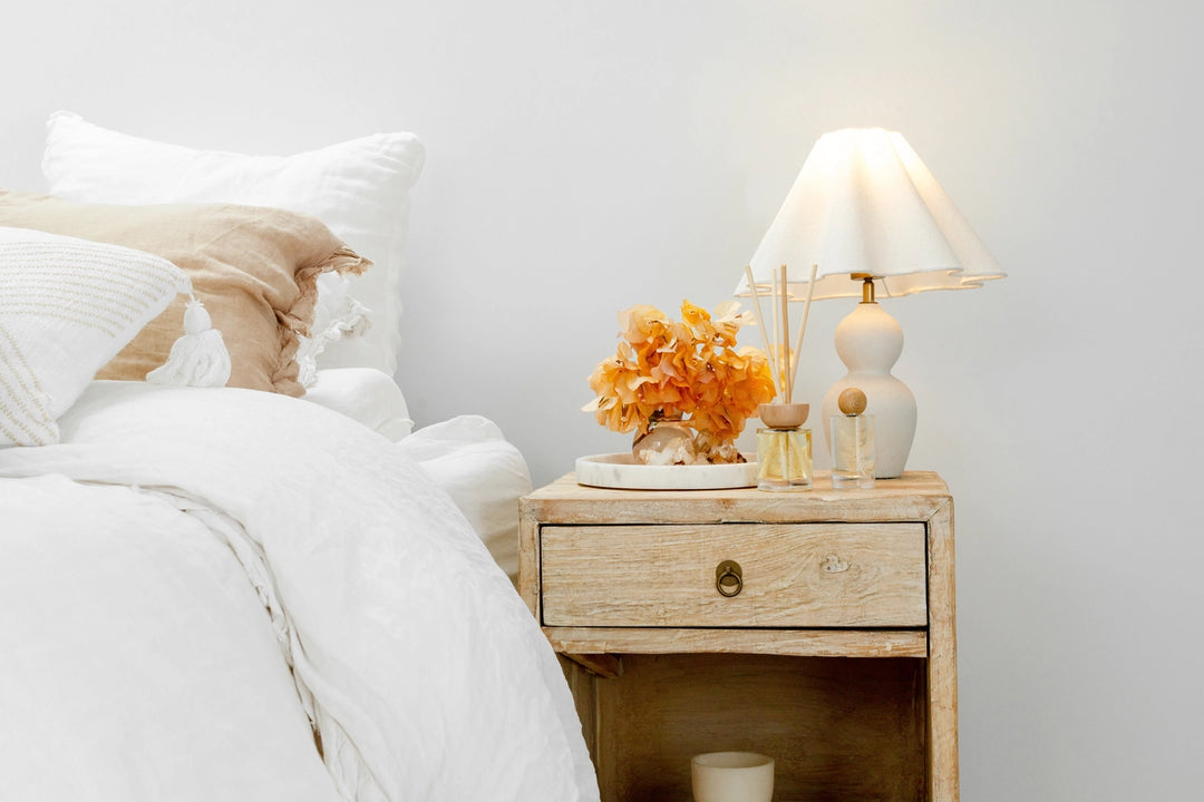 Bedroom with a nightstand featuring a lamp and decorative items.
