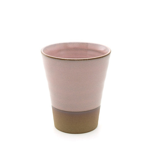 Pink ceramic cup with brown base on a white background