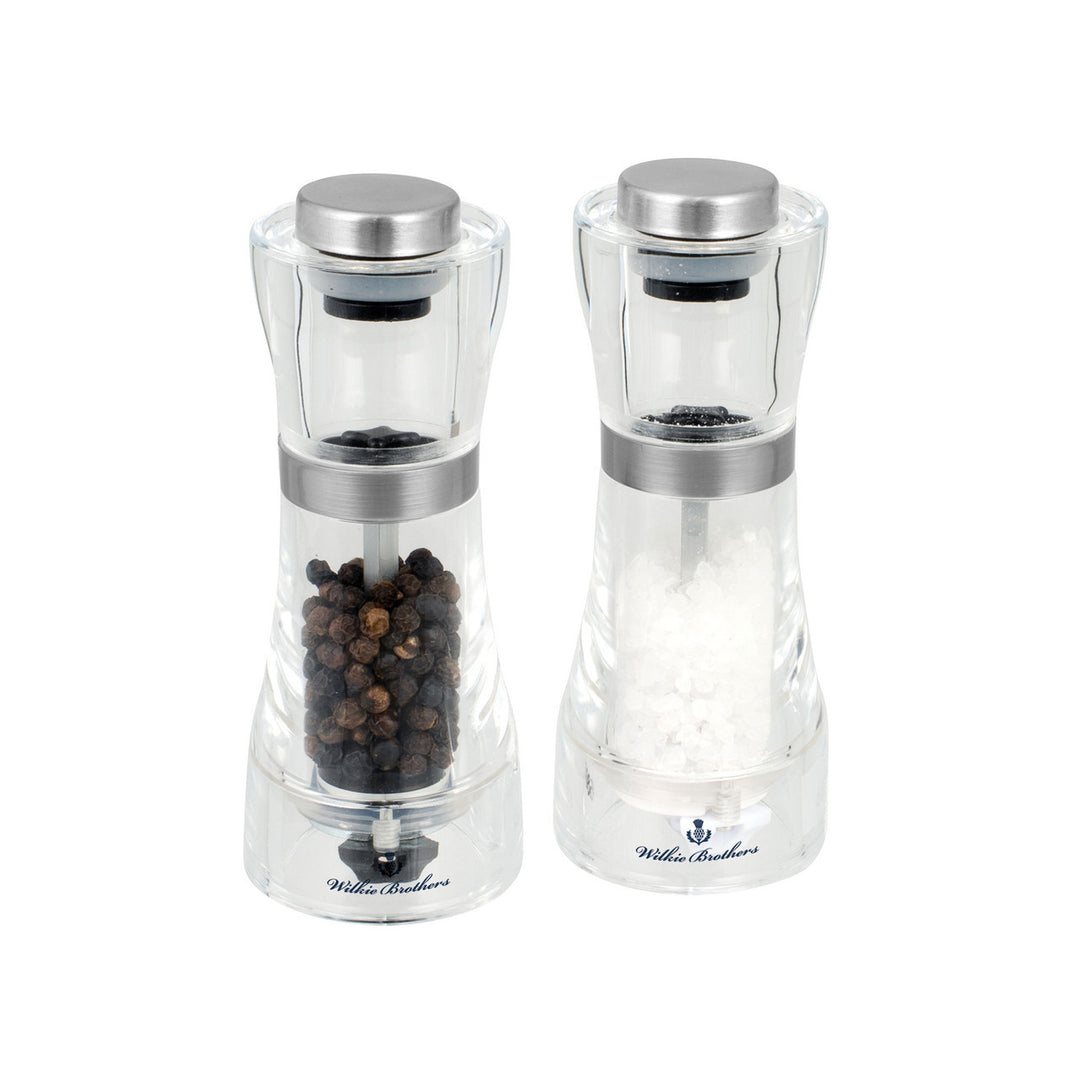 Two clear pepper mills with silver tops on a white background