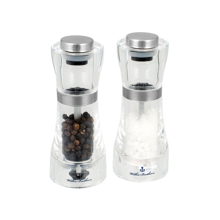 Two clear pepper mills with silver tops on a white background