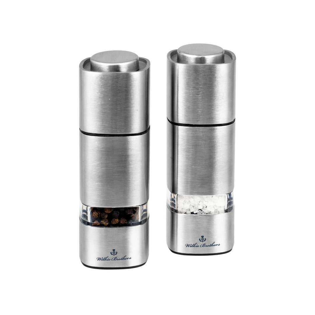 Two silver pepper mills on a white background