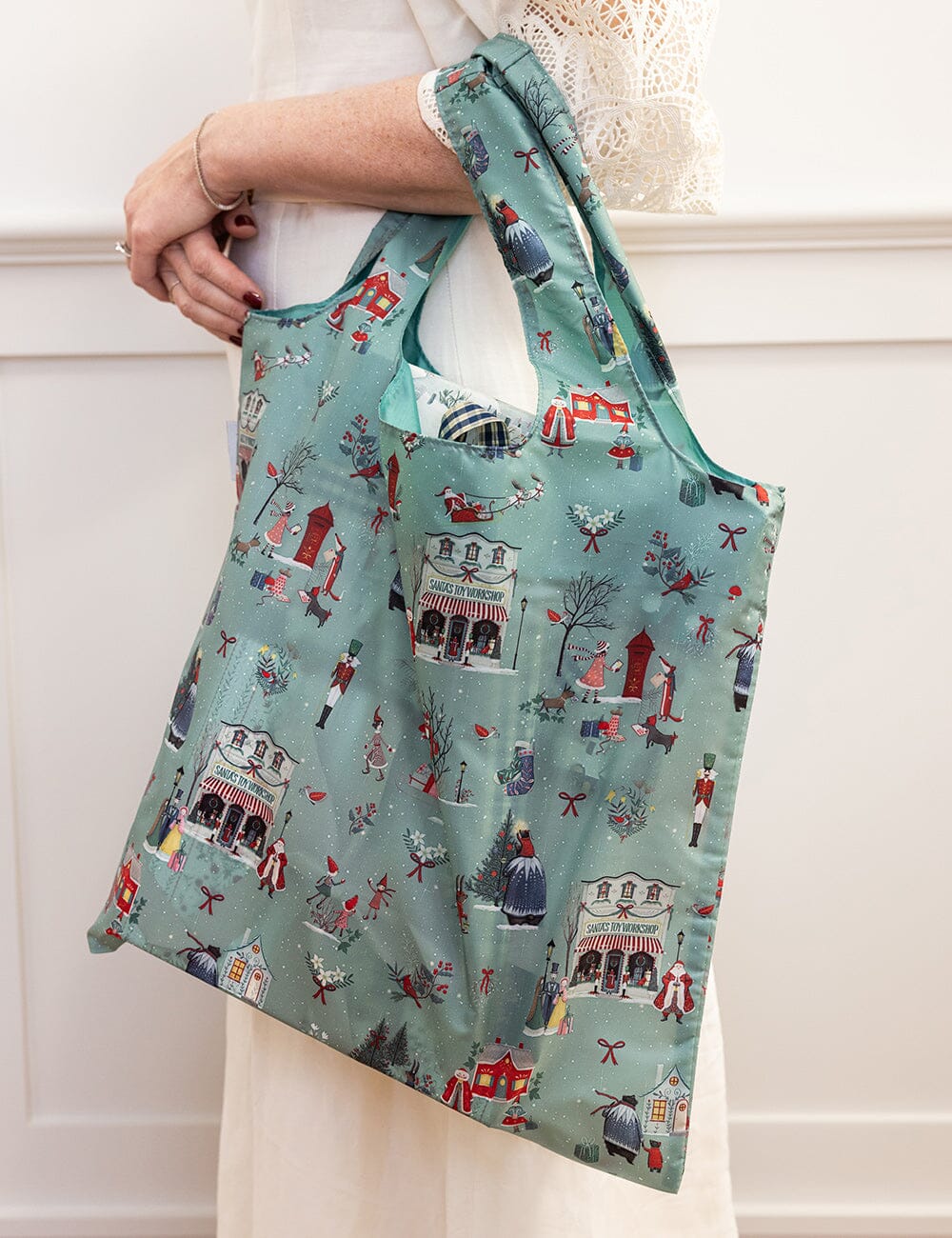 Reusable bag with Christmas theme over a persons arm