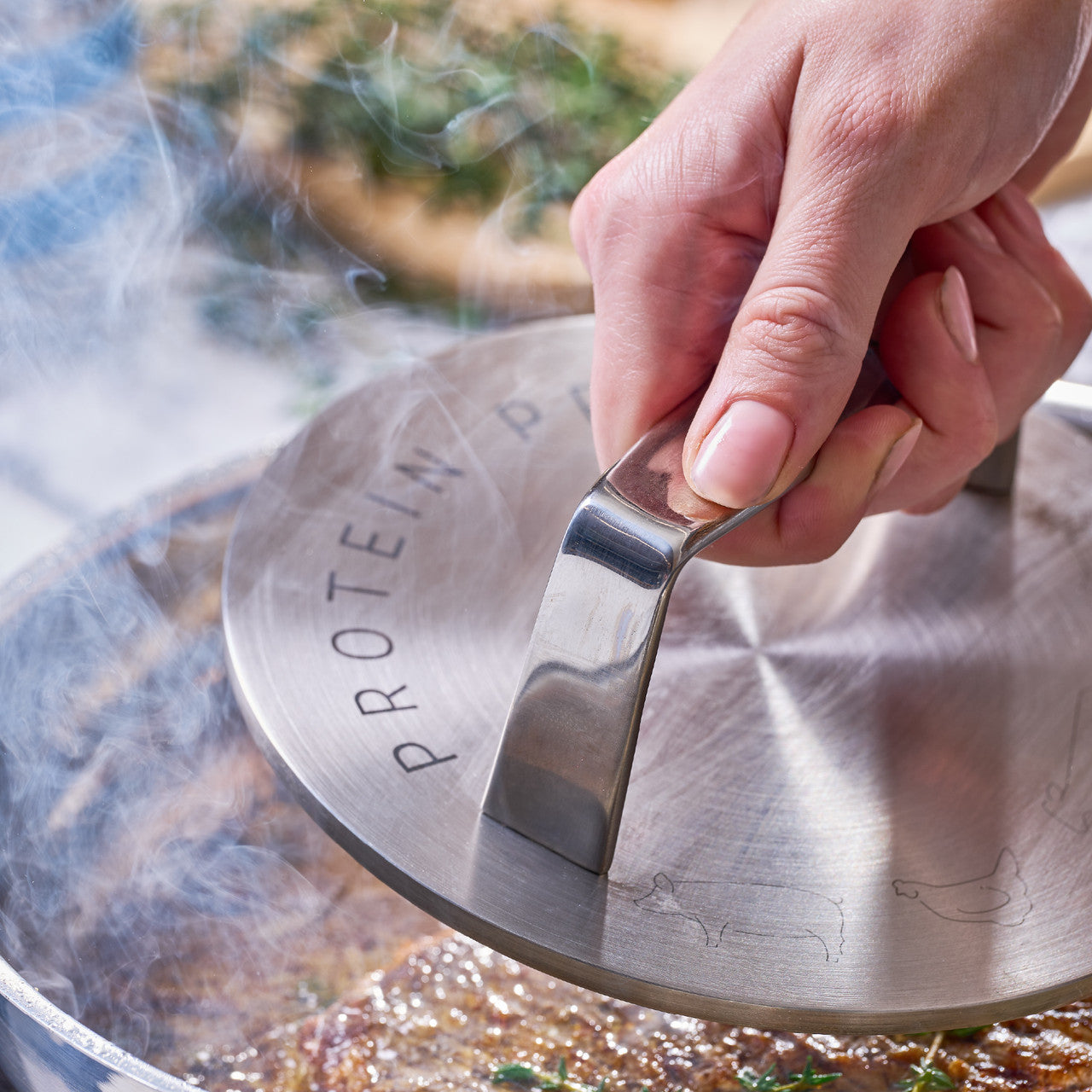 Hand using a metal protein press in a frypan with food in it