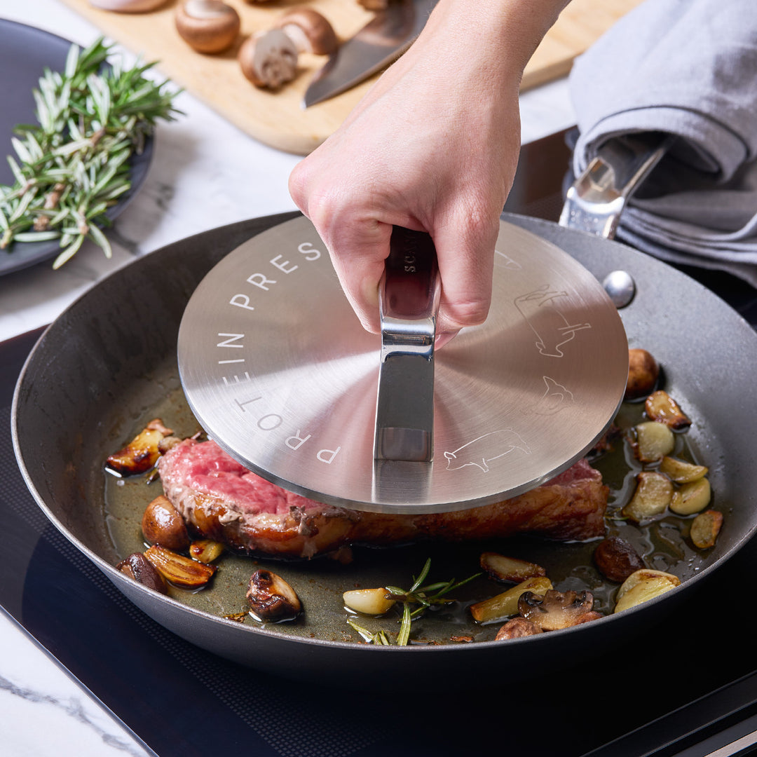 Hand using a protein press on a pan with food