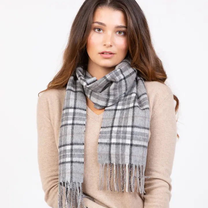 Woman wearing a gray plaid scarf on a white background