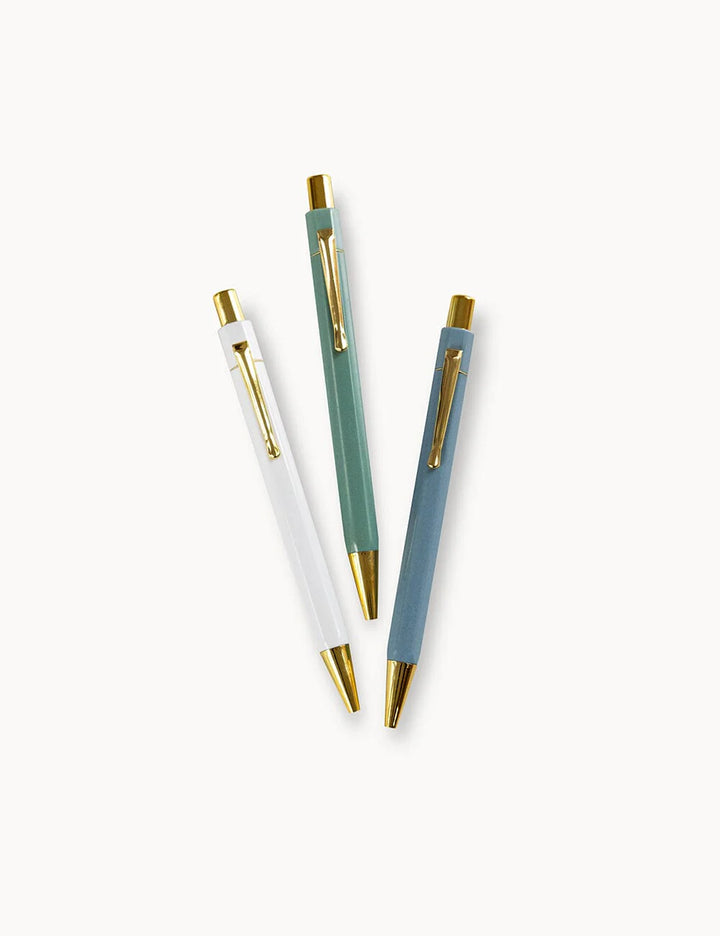 Three pens with different colored bodies and gold accents on a white background
