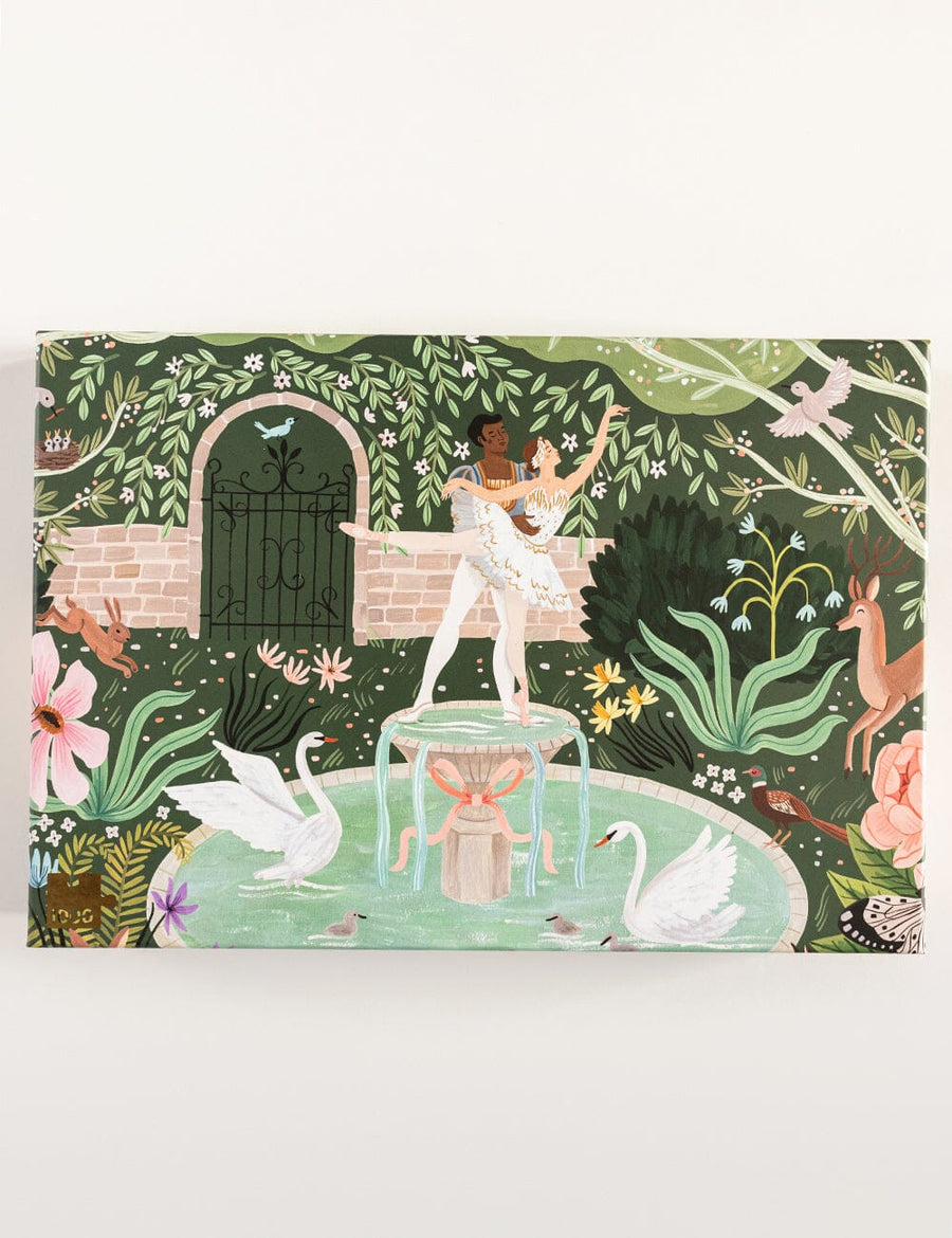 Decorative box jigsaw puzzle with a garden scene featuring a statue, swans, and flowers on a green background.