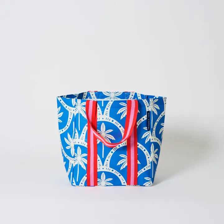 Blue & white bag with palms tree and red & pink strap on a white background
