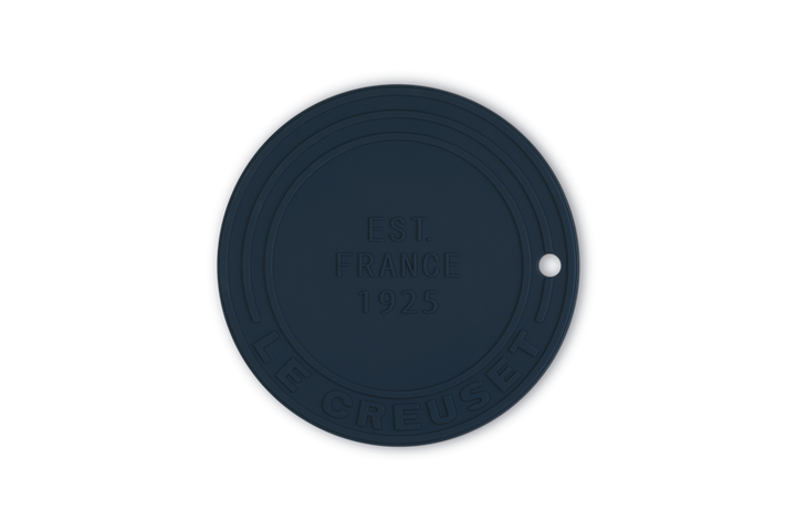 Navy blue silicone trivet with embossed text on a white background