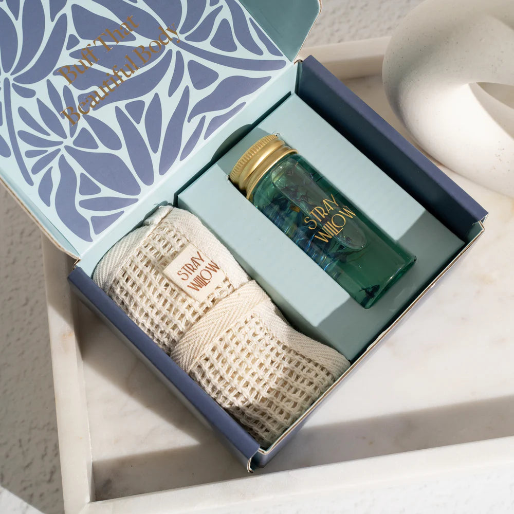 Gift set with a bottle and towel in a decorative box on a marble surface