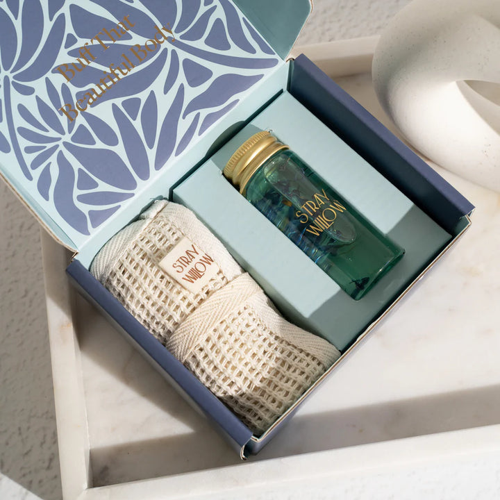 Gift set with a bottle and towel in a decorative box on a marble surface