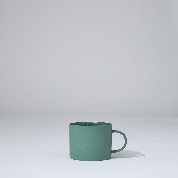 Green mug on a light gray background