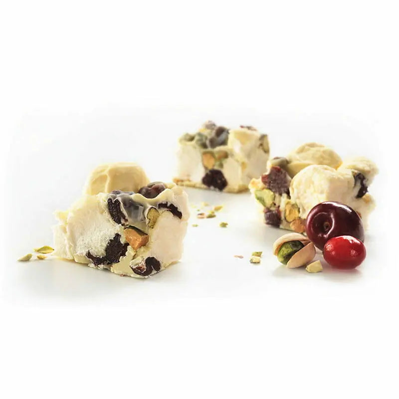 White chocolate rocky road with cherries and pistachios on a white background 