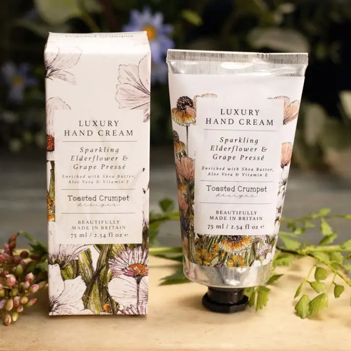 Luxury hand cream packaging with floral design on a wooden surface.