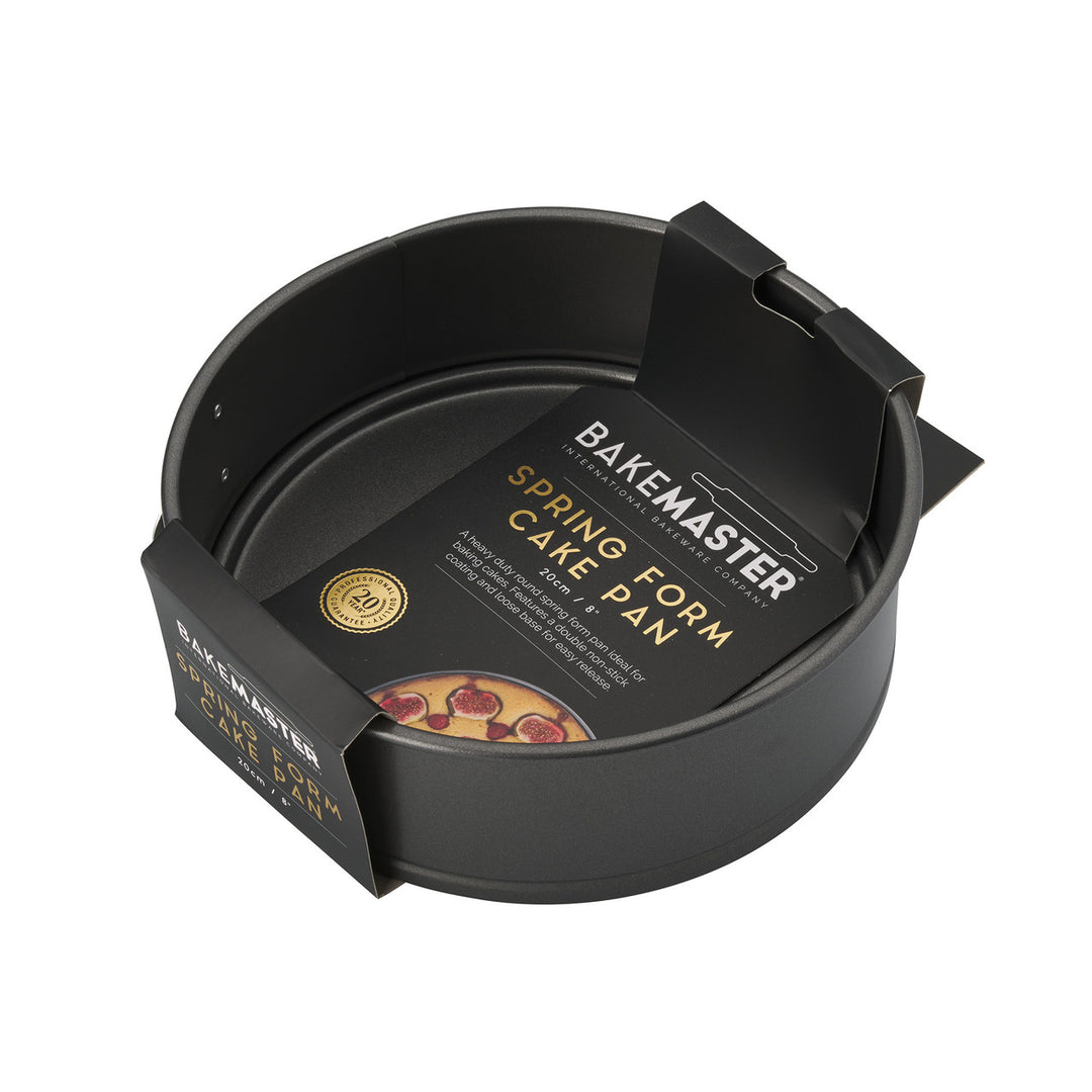 Black spring form cake pan with packaging on a white background