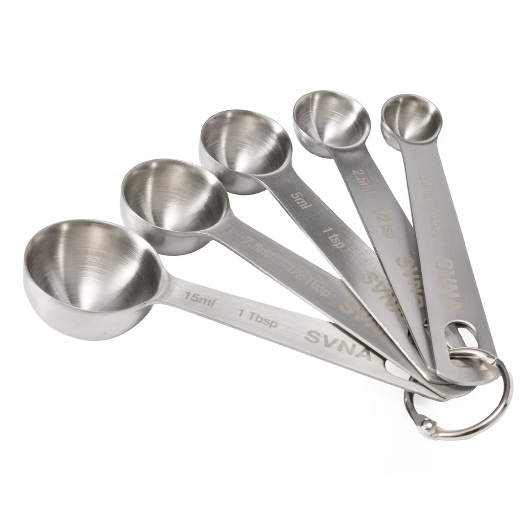 Set of stainless steel measuring spoons withSVNA branding on a white background