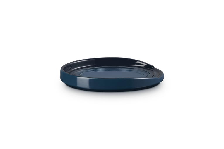 Navy blue ceramic spoon rest on a white background