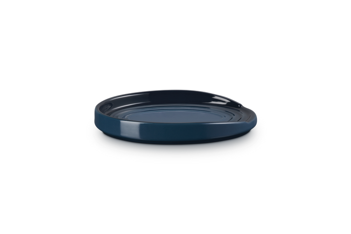 Navy blue ceramic spoon rest on a white background