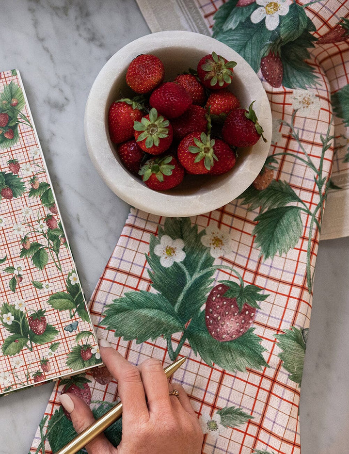 Bowl of strawberries on a table with strawberry-themed napkins