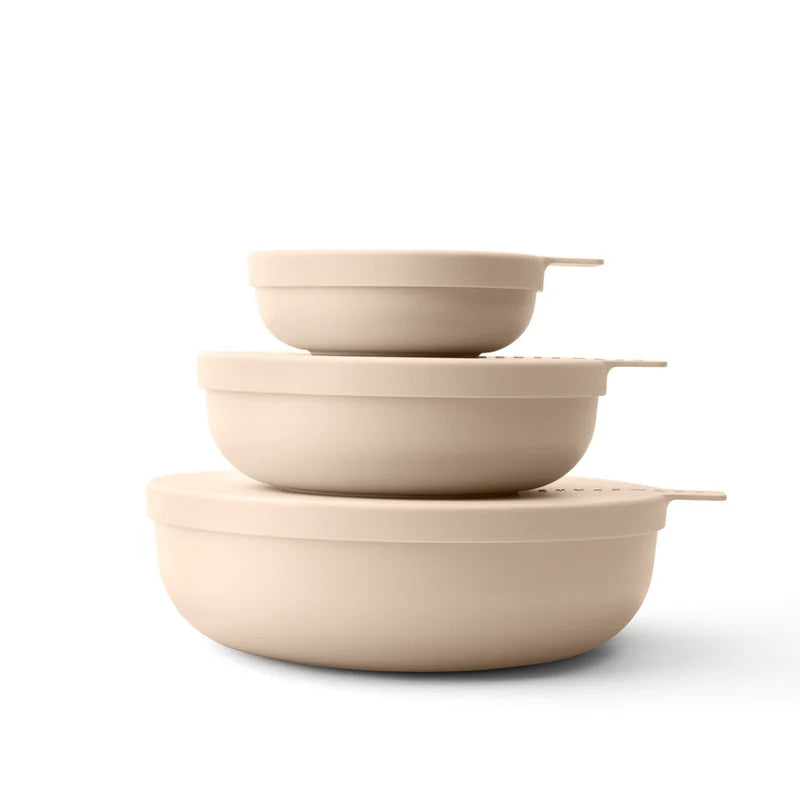 Set of three beige ceramic bowls stacked on a white background