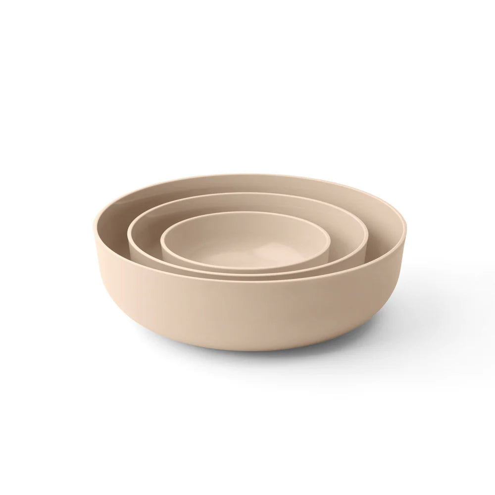 Set of three beige bowls of different sizes on a white background