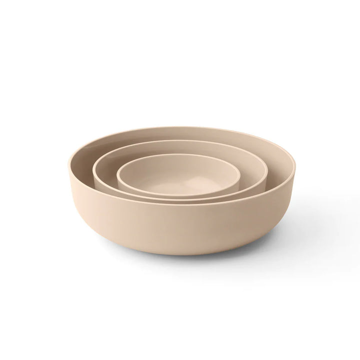 Set of three beige bowls of different sizes on a white background