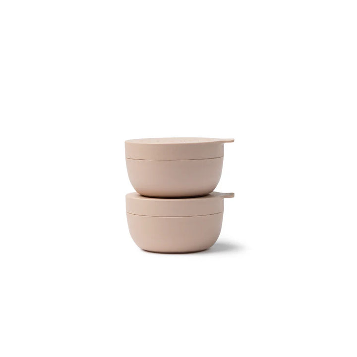 Two pink ceramic bowls stacked on a white background