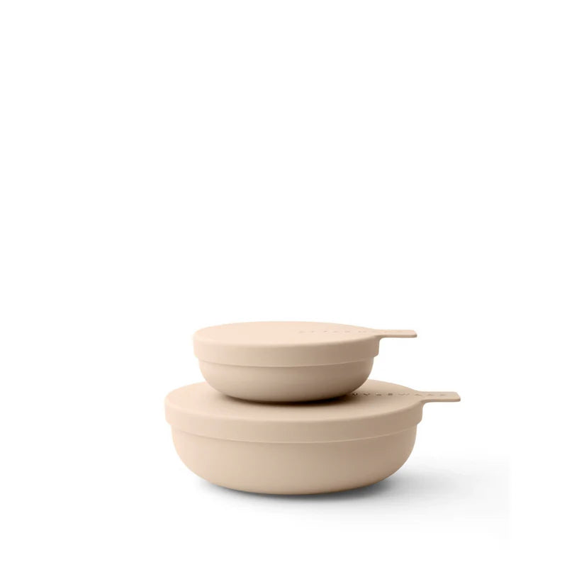 Two beige ceramic bowls stacked on a white background