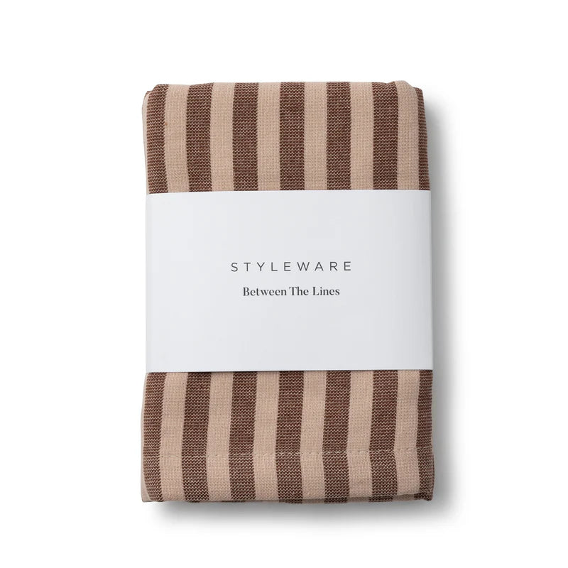 Folded brown and beige striped tea towel with a white label on a white background