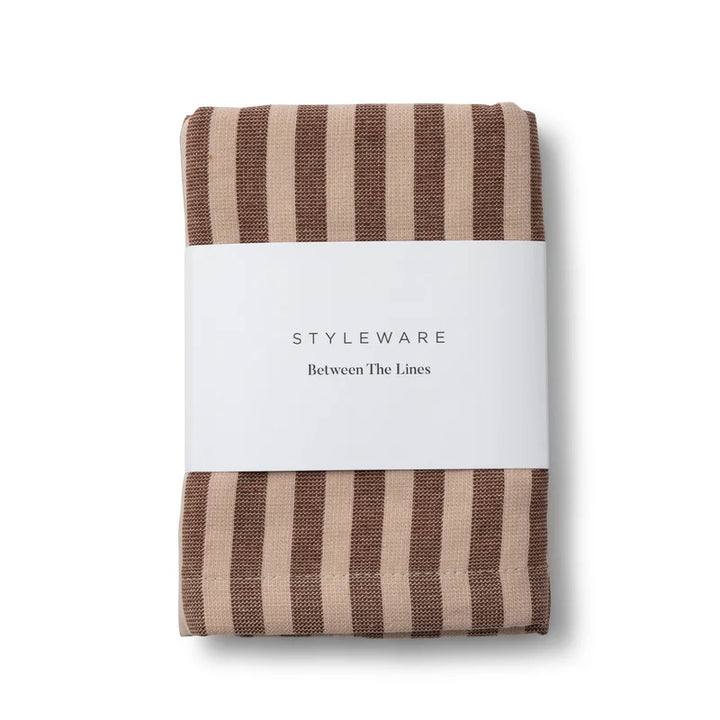 Folded brown and beige striped tea towel with a white label on a white background