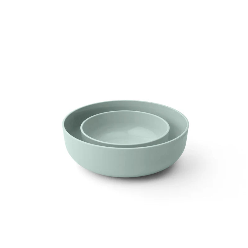 Two light green bowls stacked on a white background