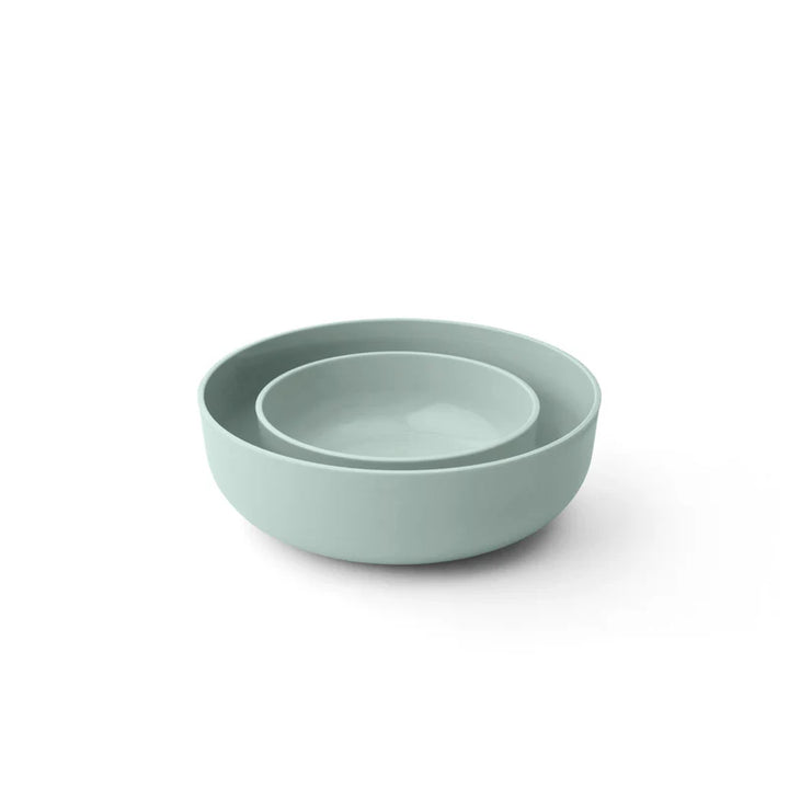 Two light green bowls stacked on a white background