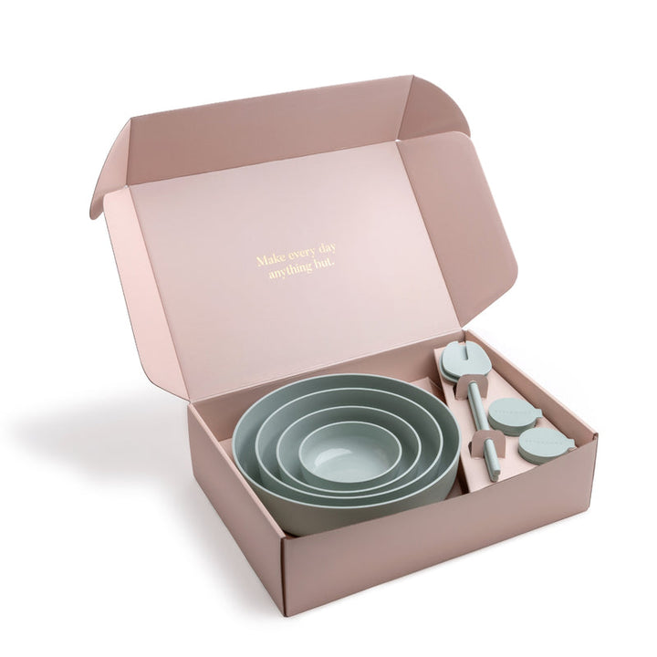 Set of green bowls and salad servers in a pink box.