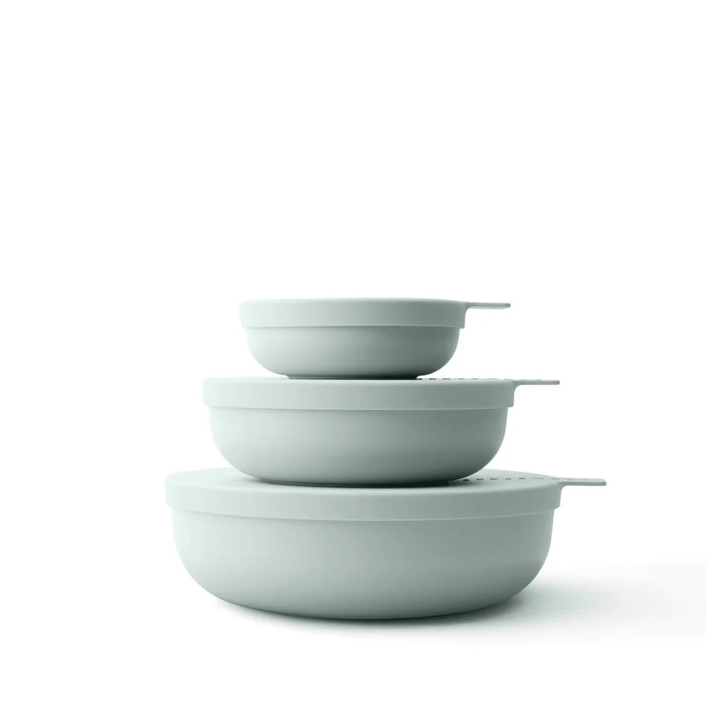 Set of three light green bowls stacked on a white background