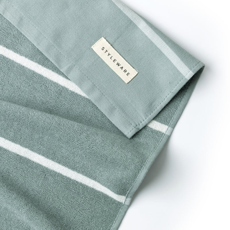Green towel with white stripes and a 'Styleware' label on a white background