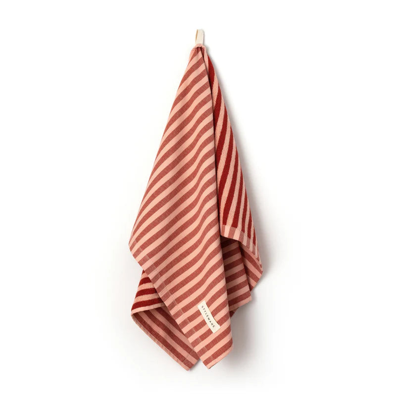 Striped tea towel with red and beige pattern on a white background