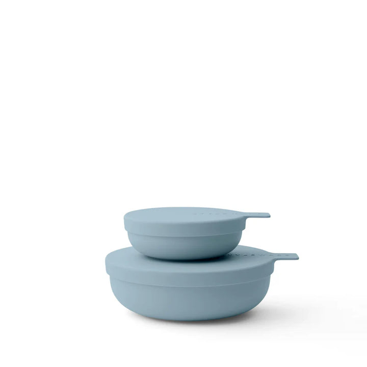 Two light blue plastic bowls stacked on a white background