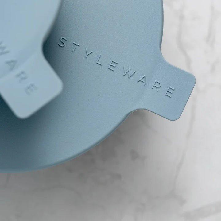 Close-up of a blue product with 'STYLEWARE' branding on a marble surface