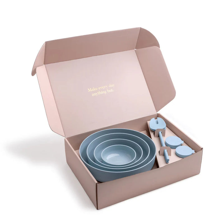 Set of blue bowls and utensils in a pink box with a quote.