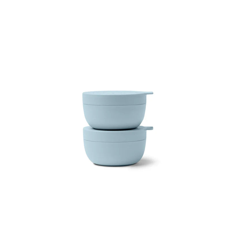 Two light blue mini bowls with lids stacked on a white background