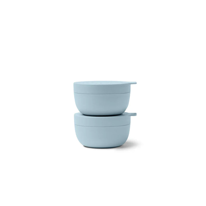 Two light blue mini bowls with lids stacked on a white background