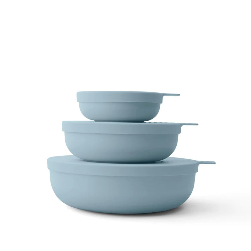 Set of three light blue nesting bowls on a white background