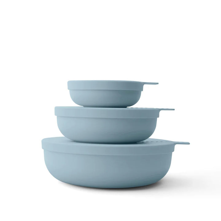 Set of three light blue nesting bowls on a white background